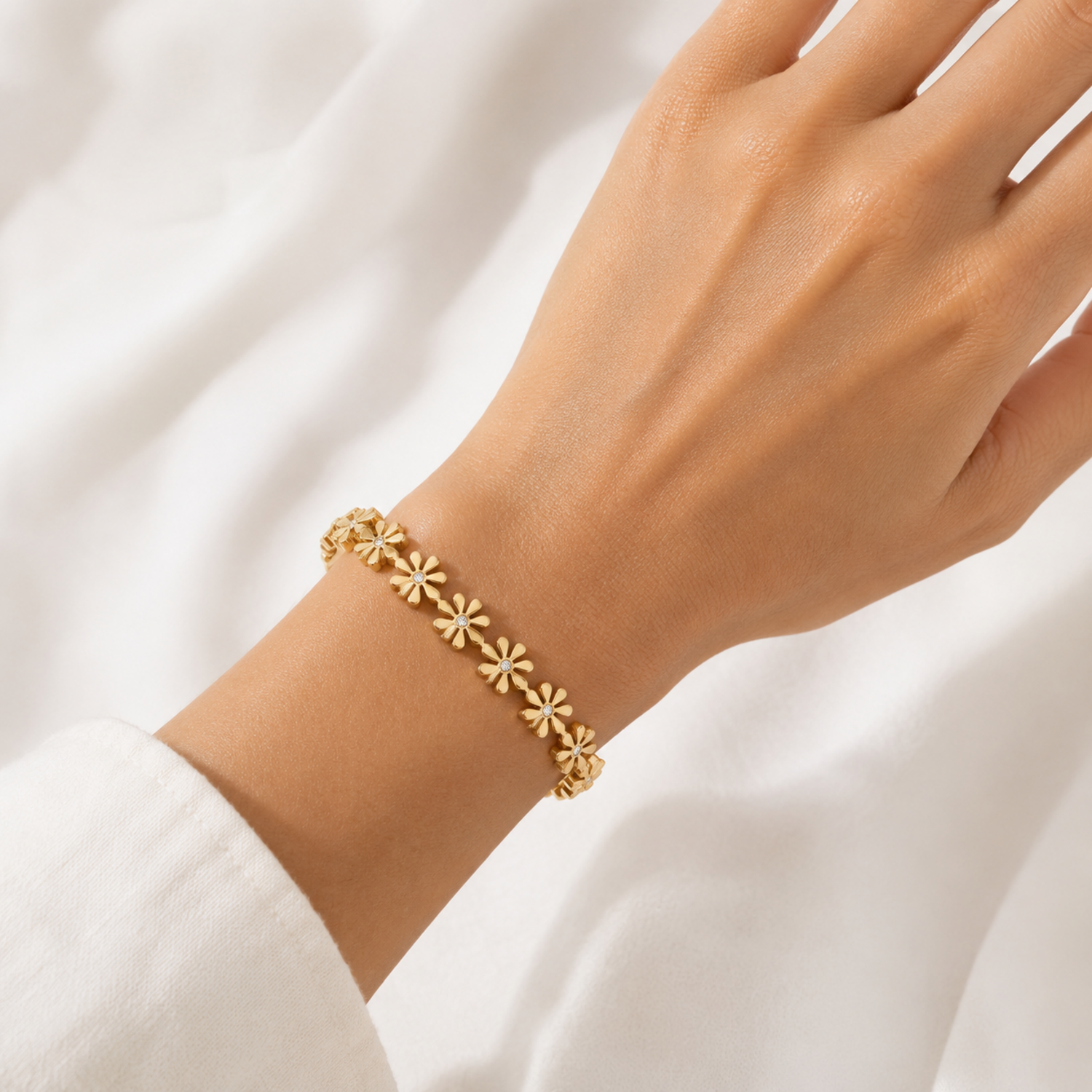 A gold-plated bangle for women featuring an intricate floral openwork design and a secure side clasp, shown on a model