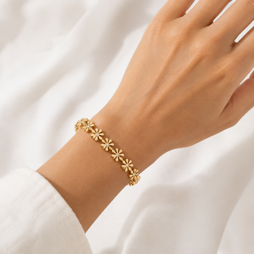 A gold-plated bangle for women featuring an intricate floral openwork design and a secure side clasp, shown on a model