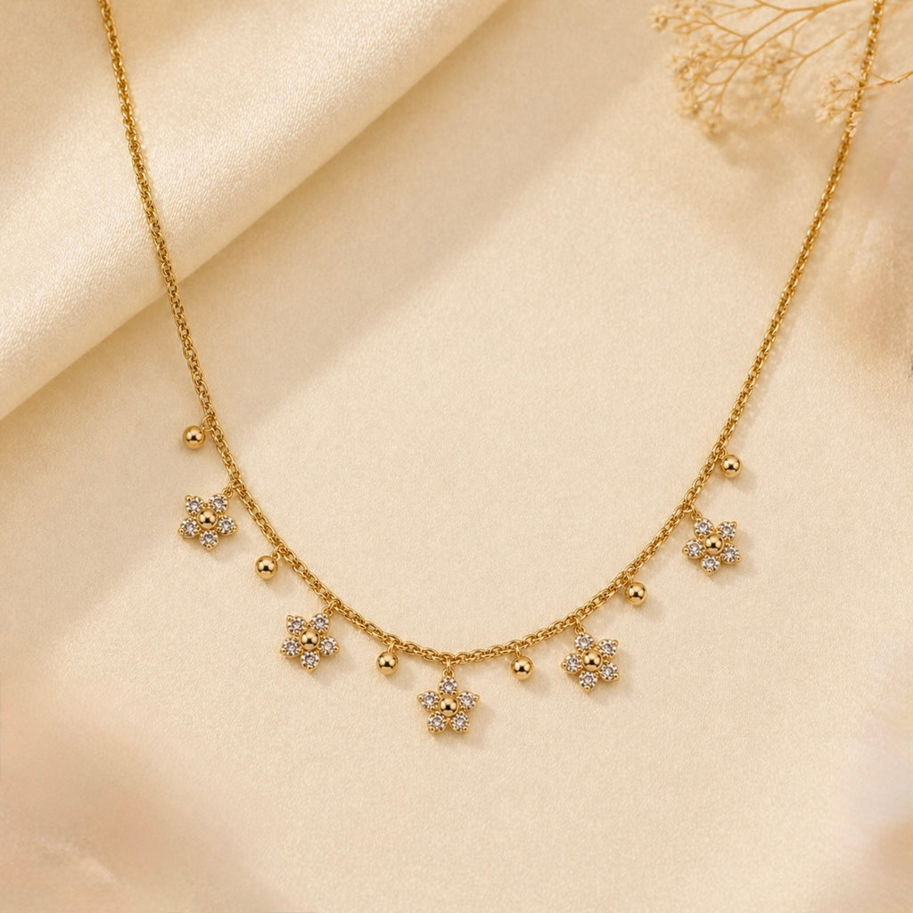 A gold-plated stainless steel chain for women featuring five crystal-encrusted flower charms and small gold beads