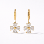A gold-plated hoop earrings for women featuring a dangling four petal charm, shown on a white background