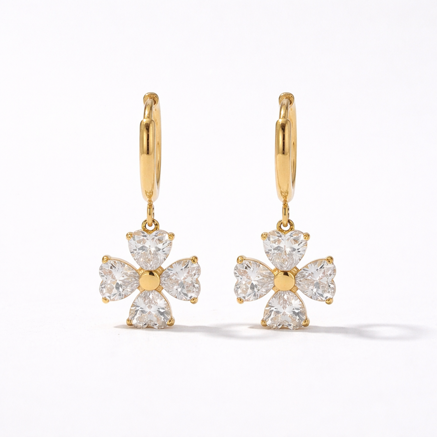 A gold-plated hoop earrings for women featuring a dangling four petal charm, shown on a white background