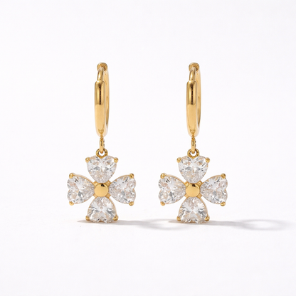 A gold-plated hoop earrings for women featuring a dangling four petal charm, shown on a white background
