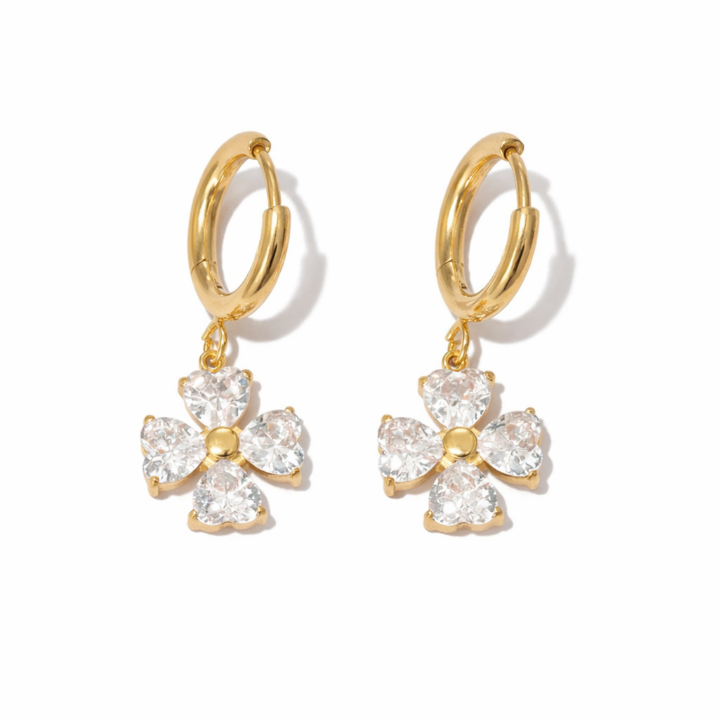 A gold-plated hoop earrings for women featuring a dangling four petal charm, displayed on a white background