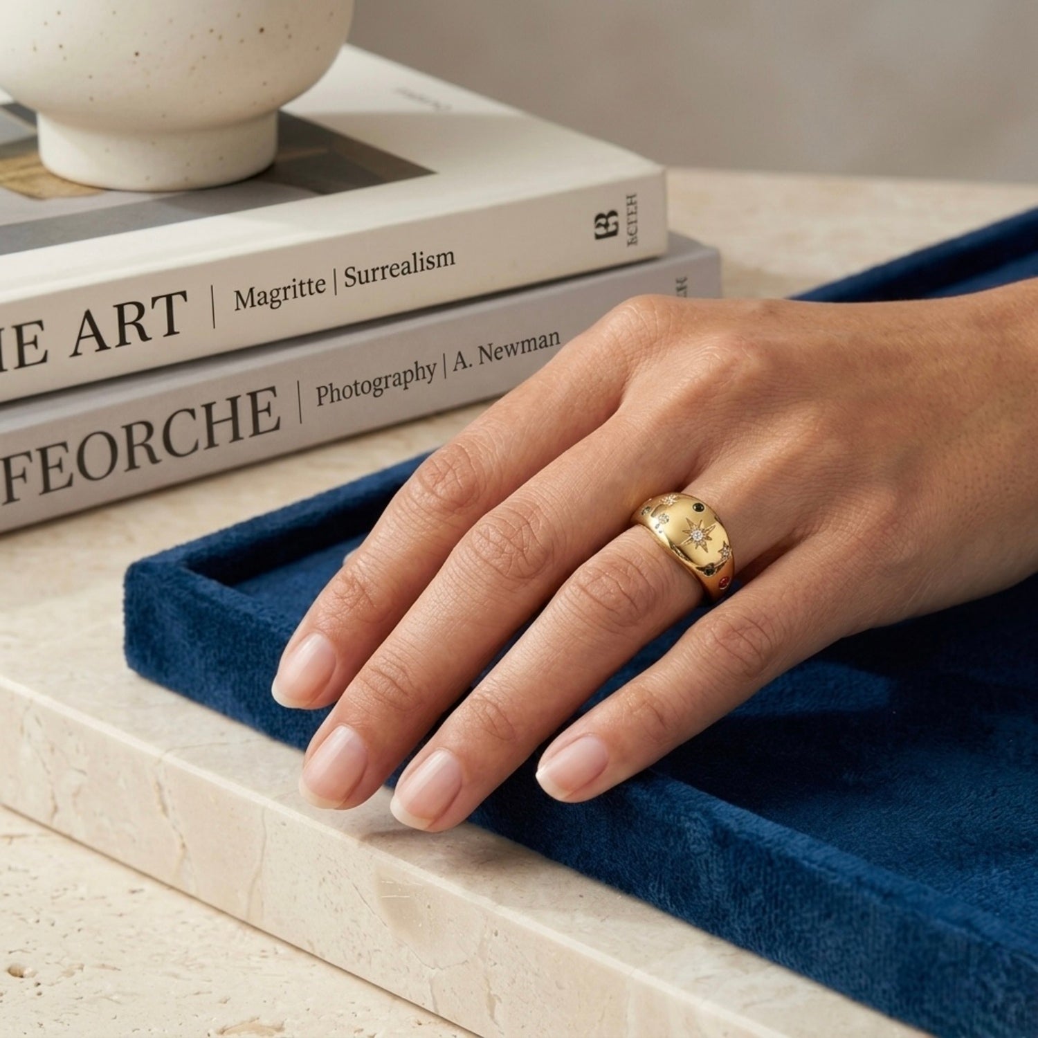 Adjustable dome ring for women featuring etched starbursts and colorful blue, pink, and clear stones on a model hand