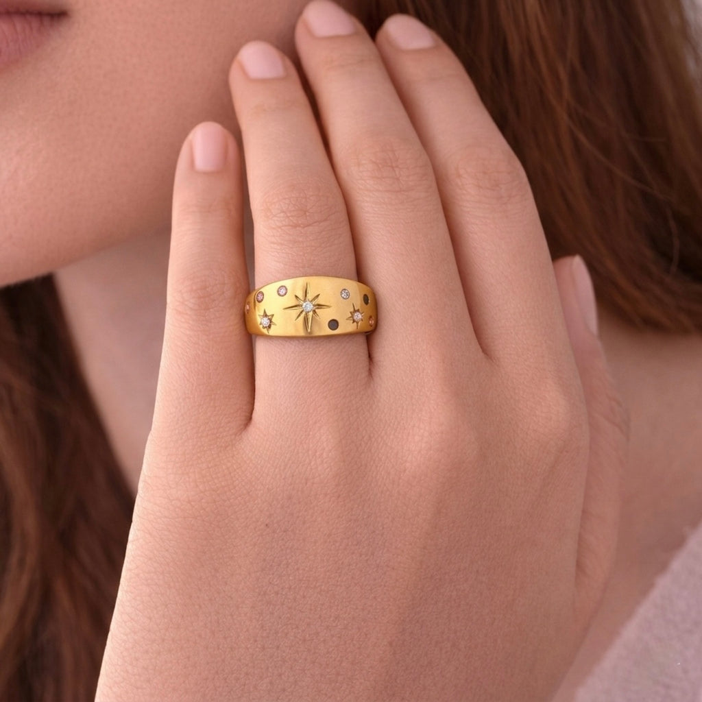 A close view of an adjustable dome ring for women featuring etched starbursts and colorful blue, pink, and clear stones