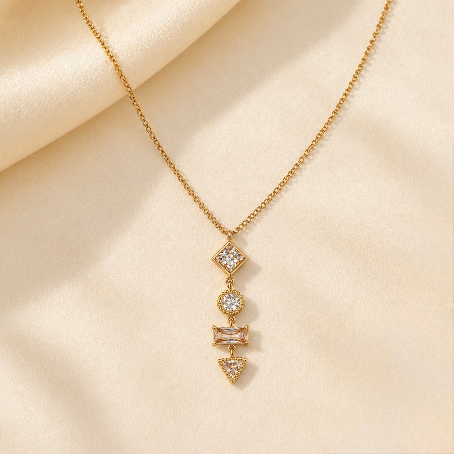 A gold-plated stainless steel chain for women featuring a vertical pendant with four different geometric crystal shapes