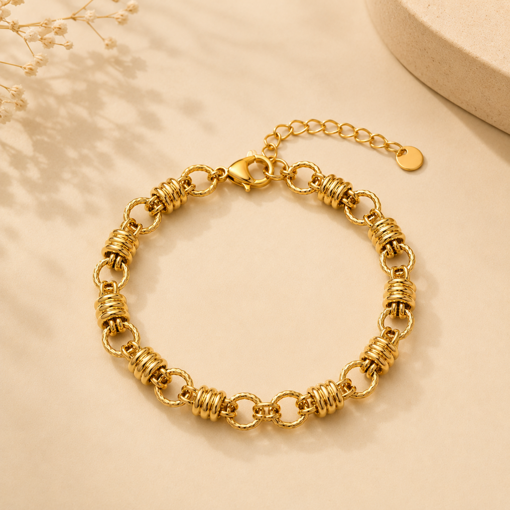 A gold-plated chain bracelet for women featuring thick polished links and textured coiled metal stations.