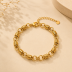 A gold-plated chain bracelet for women featuring thick polished links and textured coiled metal stations.