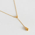 A gold-plated stainless steel chain for women featuring a Y-shaped lariat design with two polished teardrop-shaped pendants on a white textured background.