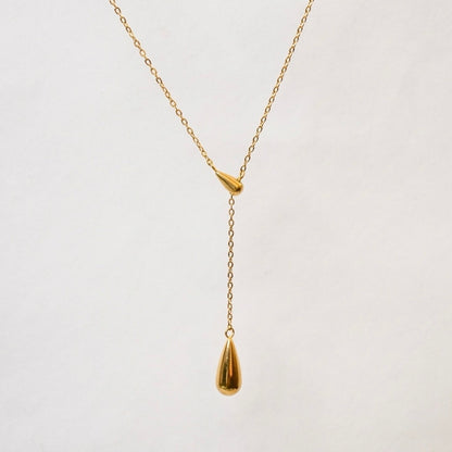 A gold-plated stainless steel chain for women featuring a Y-shaped lariat design with two polished teardrop-shaped pendants on a white textured background.