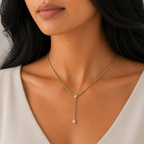 A gold-plated stainless steel chain for women in a Y-drop lariat style featuring a vine-like beaded link and teardrop crystal, shown on a model