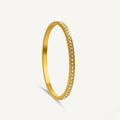 A gold-plated eternity bracelet for women featuring a continuous row of round-cut crystals and a secure side-clasp.