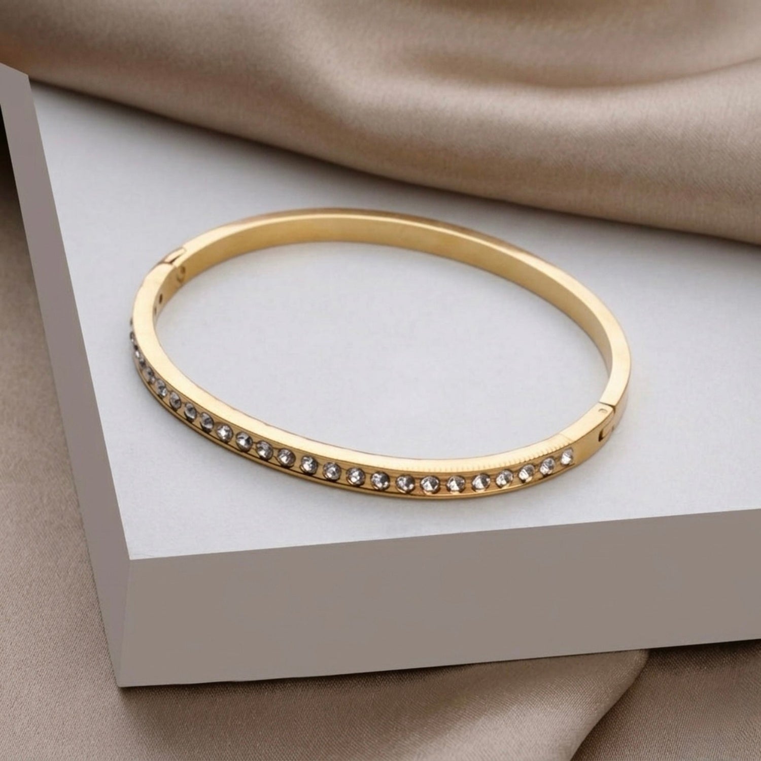 A close-view of a gold-plated eternity bracelet for women featuring a continuous row of round-cut crystals and a secure side-clasp.