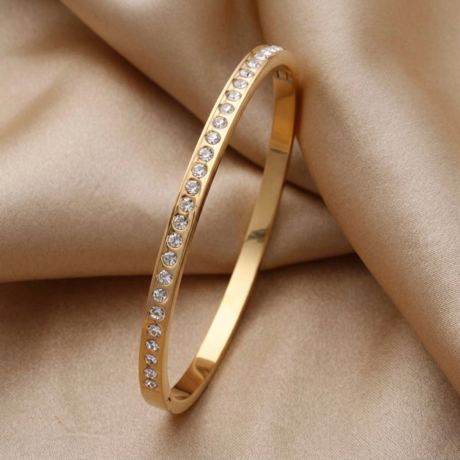 A gold-plated eternity bracelet for women featuring a continuous row of round-cut crystals and a secure side-clasp.