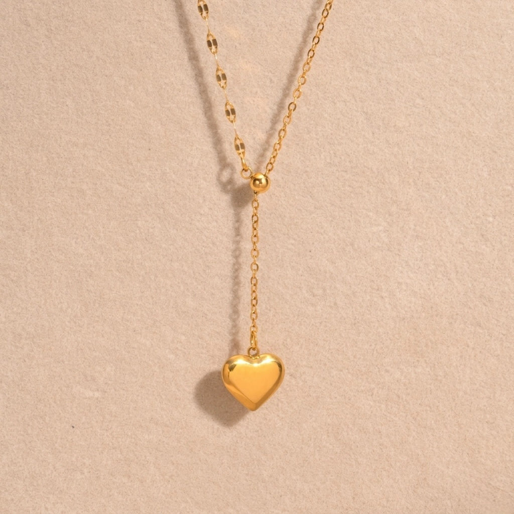 A close-view of a gold-plated stainless steel chain for women featuring a Y-shaped lariat design with a polished 3D puffed heart pendant