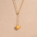 A close-view of a gold-plated stainless steel chain for women featuring a Y-shaped lariat design with a polished 3D puffed heart pendant