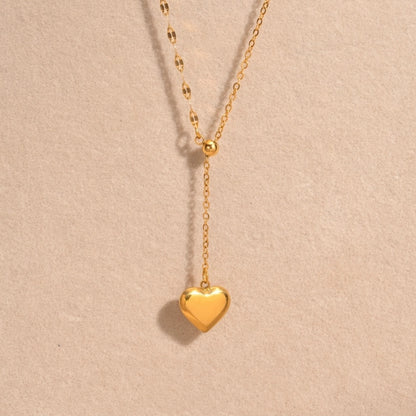 A close-view of a gold-plated stainless steel chain for women featuring a Y-shaped lariat design with a polished 3D puffed heart pendant