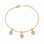 A gold-plated ladies bracelet with a fine chain featuring three dangling filigree-engraved hearts and sparkling crystal centers.