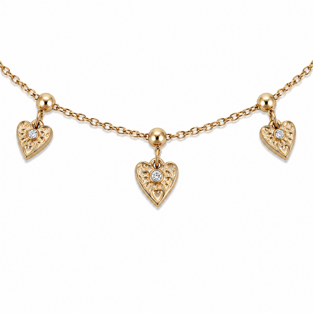 A close-view of a gold-plated ladies bracelet with a fine chain featuring three dangling filigree-engraved hearts and sparkling crystal centers.