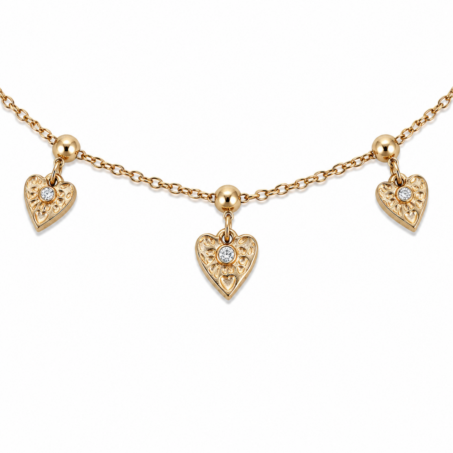 A close-view of a gold-plated ladies bracelet with a fine chain featuring three dangling filigree-engraved hearts and sparkling crystal centers.