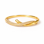 A close-view of a gold-plated twisted hinge bangle for women featuring a continuous row of sparkling white stones on a white background