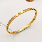 A close-view of a gold-plated hexagonal bangle for women featuring inlaid brilliant crystals and a secure side-hinge clasp.