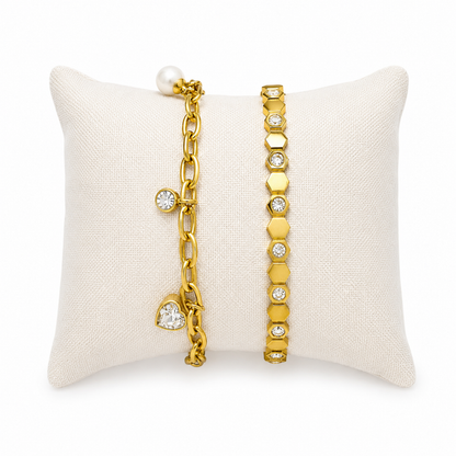 A premium two-piece gold-plated bracelet stack for women featuring a chunky paperclip charm chain with a pearl and heart drop next to a geometric honeycomb crystal bangle