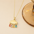 A close-view of a gold-plated stainless steel chain for women featuring a cloud pendant with four colorful dangling teardrop crystals.