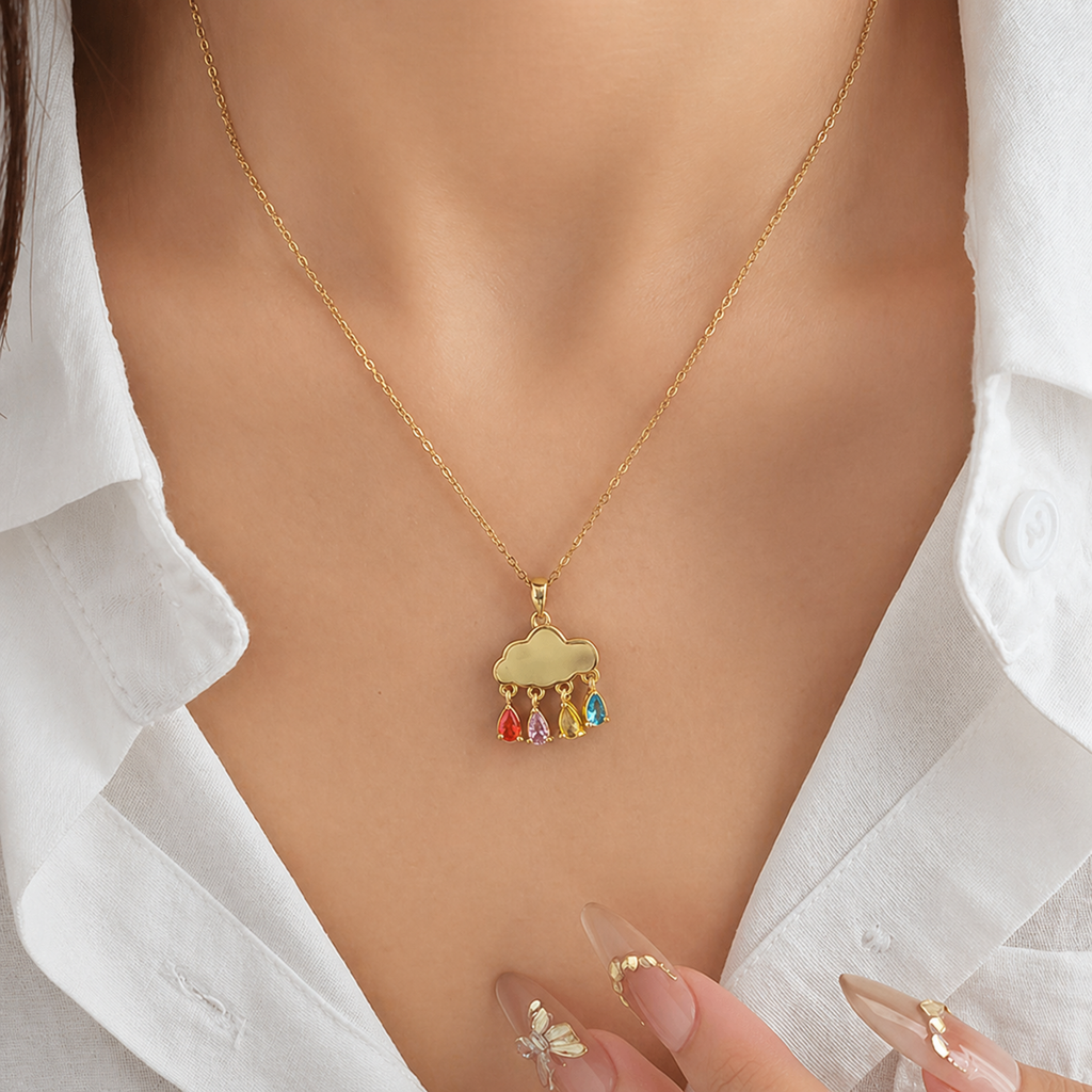 A gold-plated stainless steel chain for women featuring a cloud pendant with four colorful dangling teardrop crystals, shown on a model
