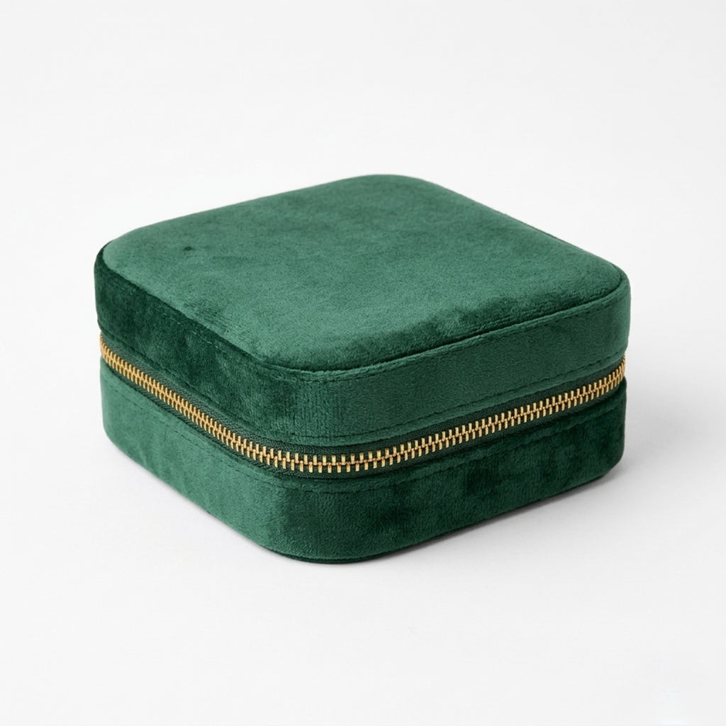 Emerald Green velvet jewelry box with a gold zipper on a white background