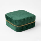 Emerald Green velvet jewelry box with a gold zipper on a white background
