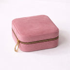 Mauve velvet jewelry box with gold zipper on a white background
