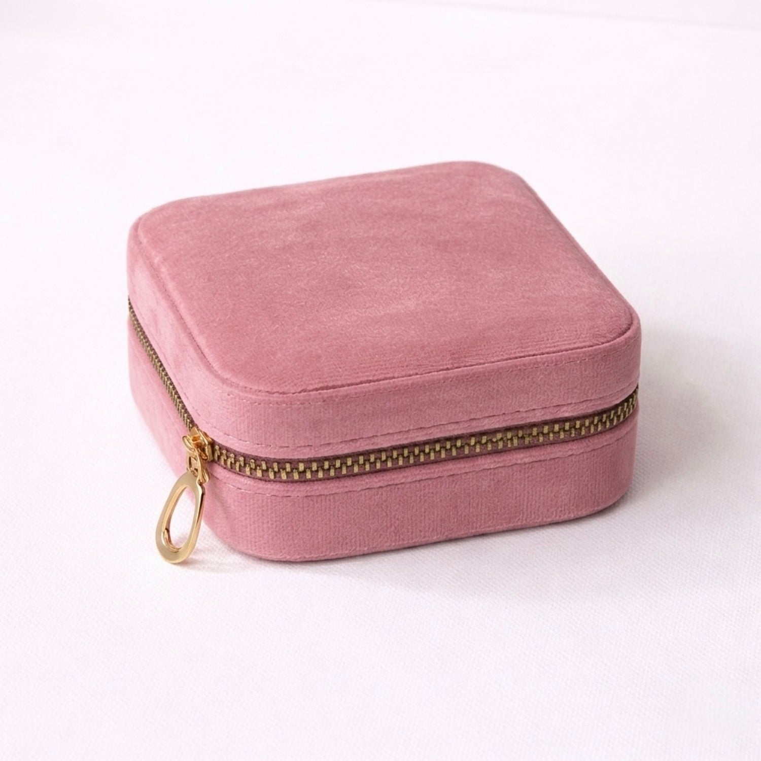 Mauve velvet jewelry box with gold zipper on a white background