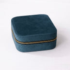 Teal Blue velvet jewelry box with a gold zipper on a white background