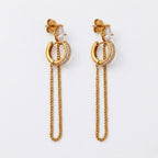 A close-view of a pair of gold-plated ear chain earrings for women connecting a crystal hoop to a marquise-cut crystal stud with a fine gold plated chain