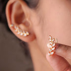 A pair of gold-plated laurel vine ear climber earrings for women featuring sparkling marquise-cut white leaves on a model