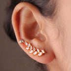 A gold-plated laurel vine ear climber earrings for women featuring sparkling marquise-cut white leaves on a model