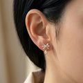 A gold-plated drop earrings for women featuring a drop earring, shown on a model