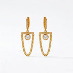 A pair of gold-plated long earrings for women featuring a hoop, a horizontal crystal bar, and a dangling gold curb chain loop, shown on a white background.