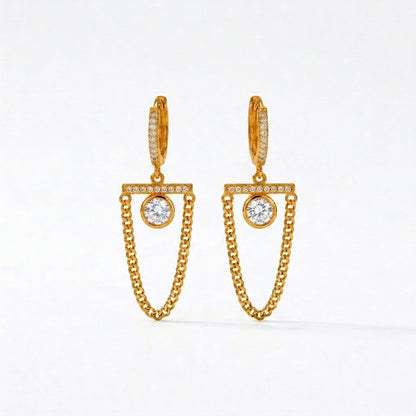 A pair of gold-plated long earrings for women featuring a hoop, a horizontal crystal bar, and a dangling gold curb chain loop, shown on a white background.