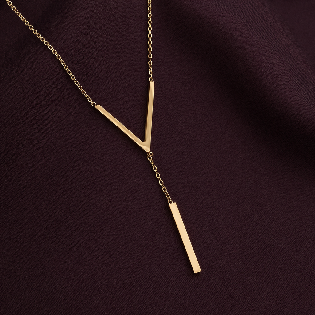 A close-view of a gold-plated stainless steel chain for women featuring a minimalist V-chevron and a long vertical bar pendant