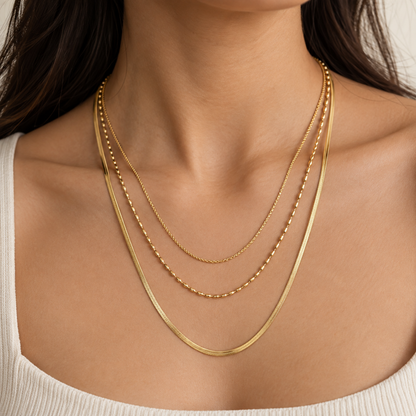 Liora layered gold necklace for women with three mixed-texture chains and gold plated on a model