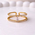 A modern gold plated adjustable ring for women with a double-band design on a white surface