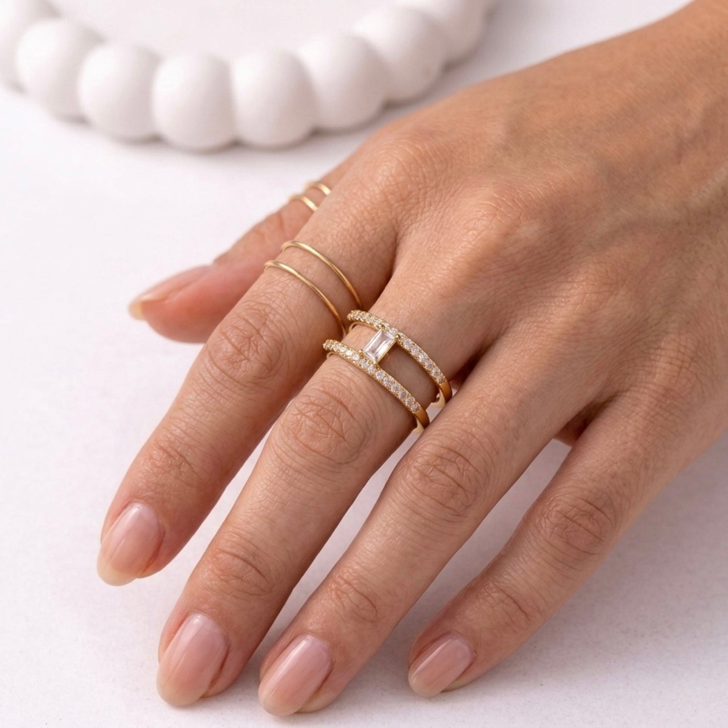 A modern gold plated adjustable ring for women with a double-band design on a model hand
