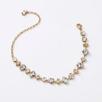 A gold-plated chain bracelet for women featuring an intricate mix of clear multi-shape stones, including brilliant, emerald, oval, and princess cuts, on a clean white background