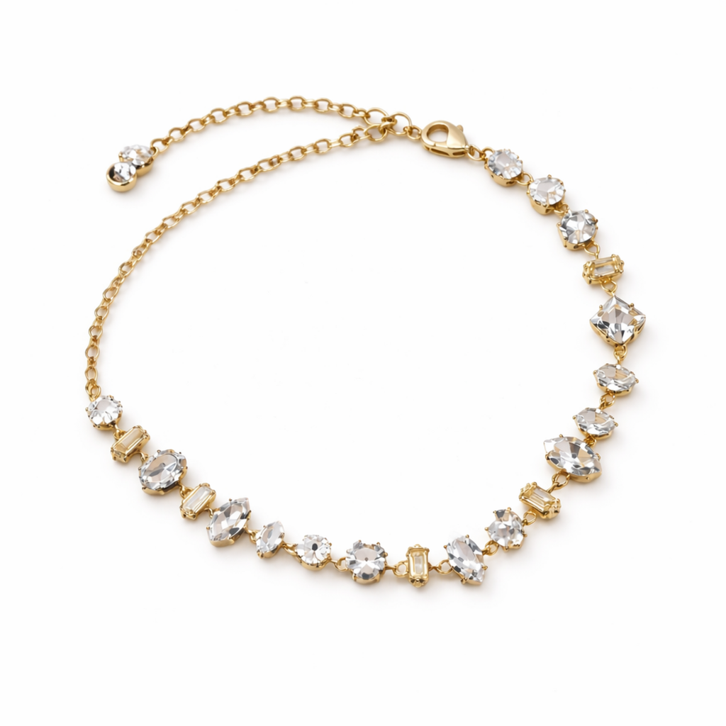 A  close-view of a gold-plated chain bracelet for women featuring an intricate mix of clear multi-shape stones, including brilliant, emerald, oval, and princess cuts, on a clean white background