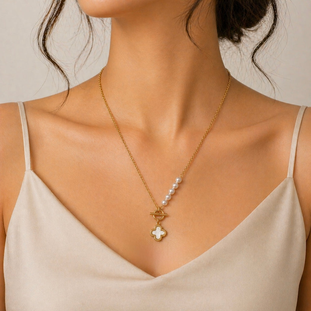 A gold-plated stainless steel chain for women featuring an asymmetrical pearl accent, a toggle clasp, and a mother-of-pearl clover charm.