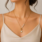 A gold-plated stainless steel chain for women featuring an asymmetrical pearl accent, a toggle clasp, and a mother-of-pearl clover charm.