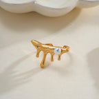 A unique 18kt gold plated stainless steel adjustable ring for women featuring a molten gold drip design with a single white pearl, displayed on an aesthetic neutral background