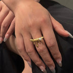 A unique 18kt gold plated stainless steel adjustable ring for women featuring a molten gold drip design with a single white pearl displayed on a model hand